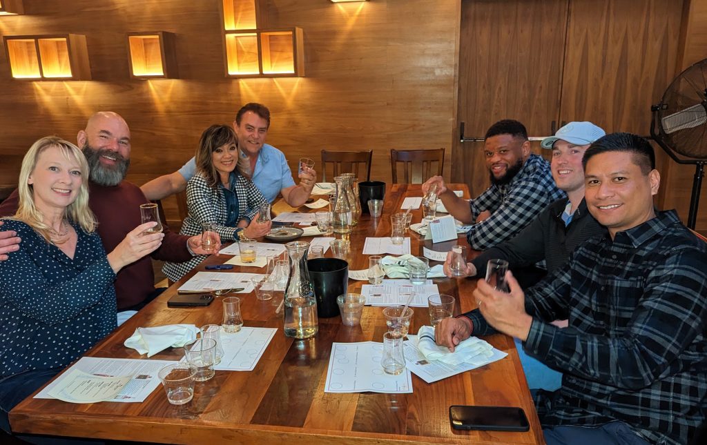 Guests raising Glencairn glasses at a guided Whiskey EDU tasting dinner